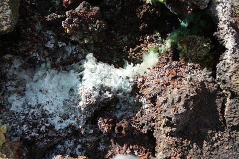 Eldfjallaútfellingar. Kristjánít fannst í grænleita massanum. 